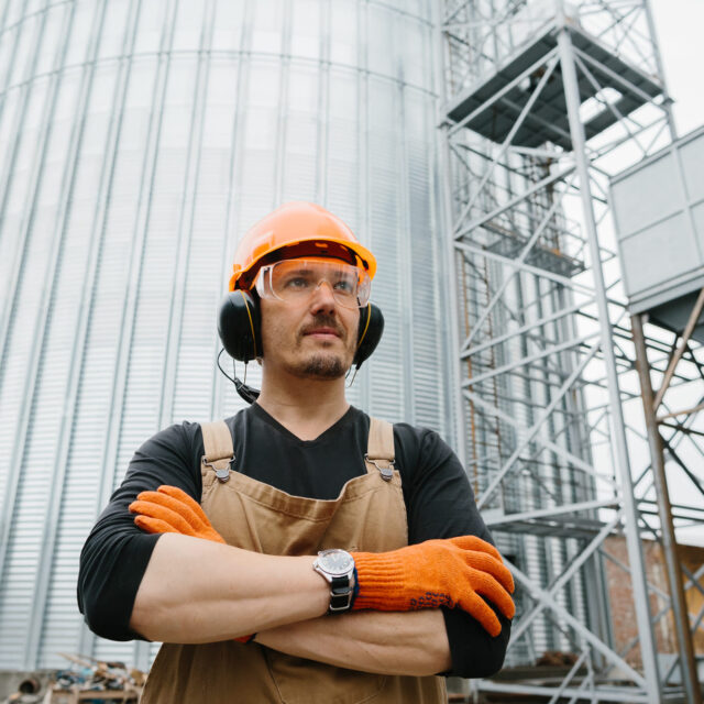 a-male-worker-in-front-of-grain-silos-2024-09-19-18-05-53-utc