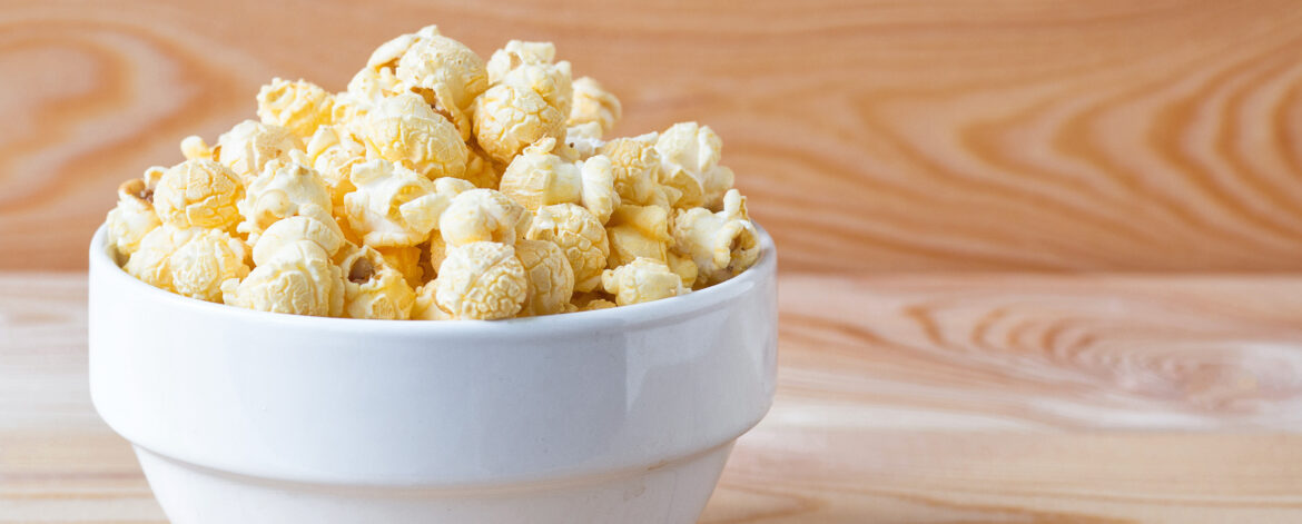 Air salty popcorn. A bowl of popcorn on a wooden table.